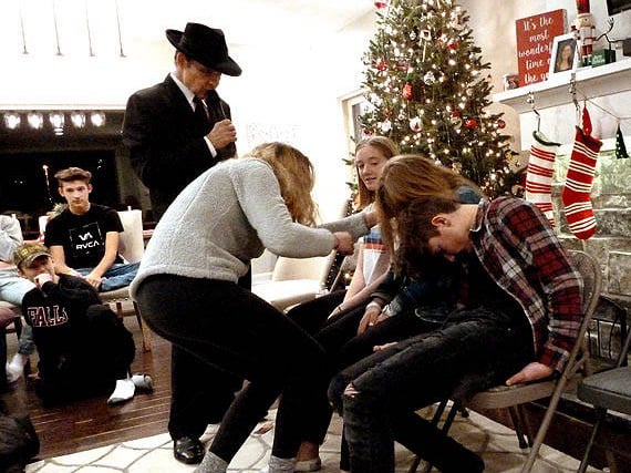 A girl inspecting people's ear lobes at a Chicago area Sweet 16 party hypnosis show.