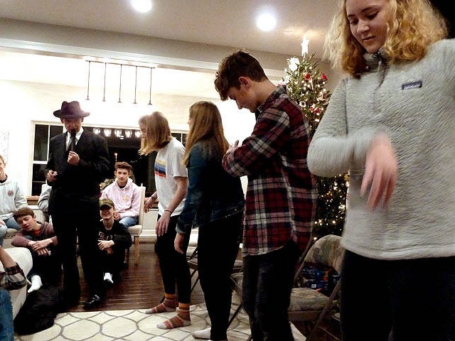 A row of teens standing frozen in place at a Chicago area Sweet 16 party hypnosis show.