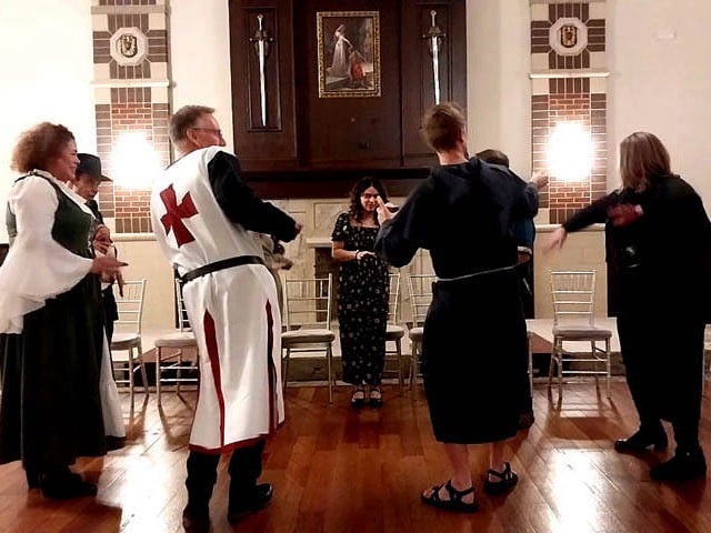 Hypnotized volunteers dance in a circle at a Chicago area corporate holiday hypnosis show.