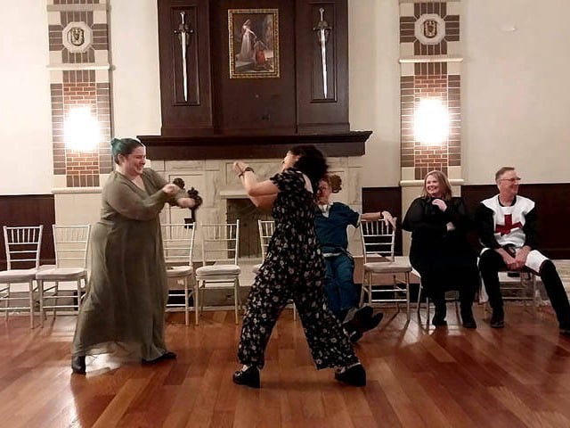 Hypnotized women face off at a Chicago area corporate holiday hypnosis show.