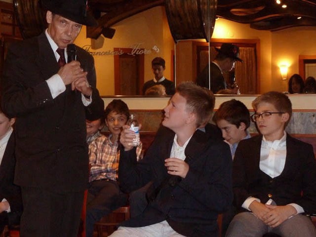 Confused boy holding a bottle of water at a Chicago area bar mitzvah hypnosis show. 