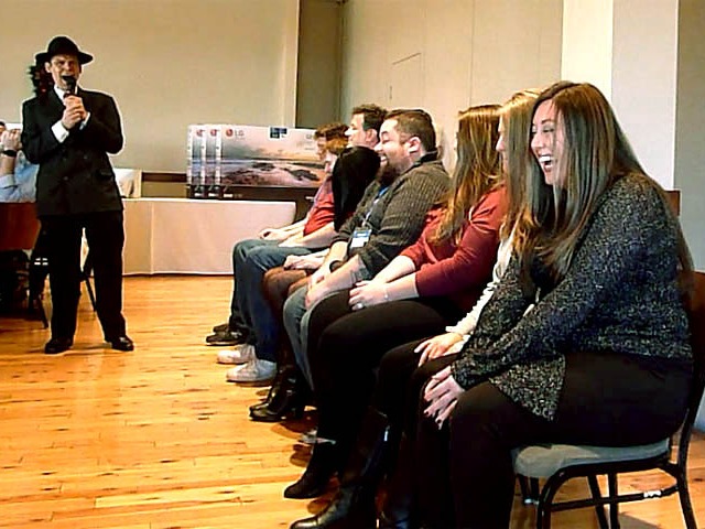 Volunteers laugh uncontrollably at a Chicago area corporate hypnosis show.