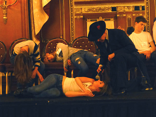 Hypnotist Mister Vibe interviews girl who has fallen to the floor at a Chicago college hypnosis show.