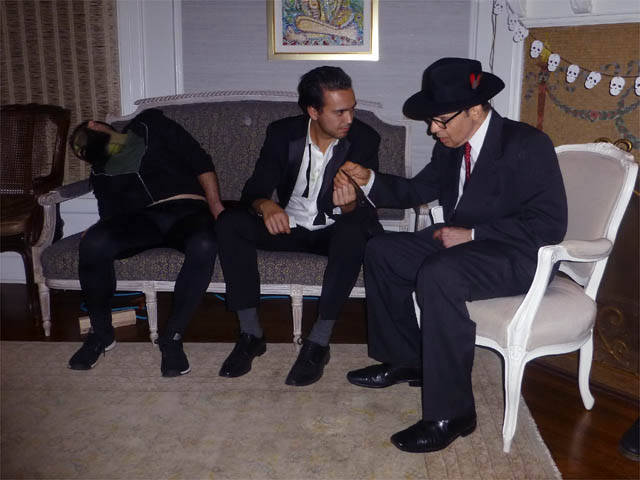 Hypnotized man shows hypnotist his identification at a Chicago house party.