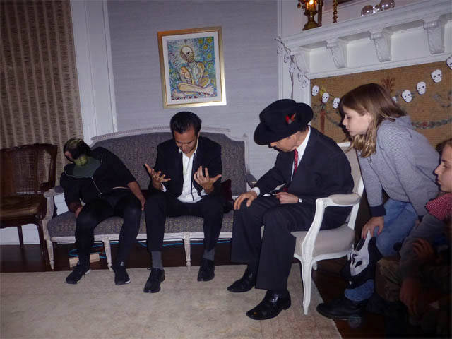 Hypnotized man stares confused at his fingers at a Chicago house party.