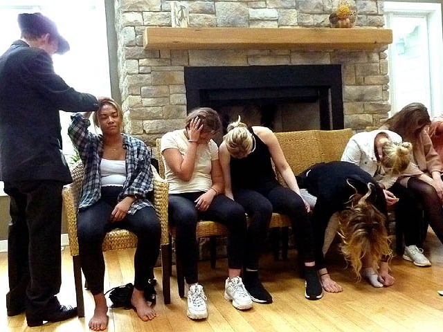 Volunteer's hand stuck to her head at Chicago area sorority hypnosis show.